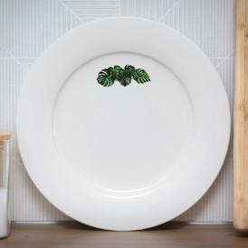 White plate with a small monstera leaves illustration near the rim